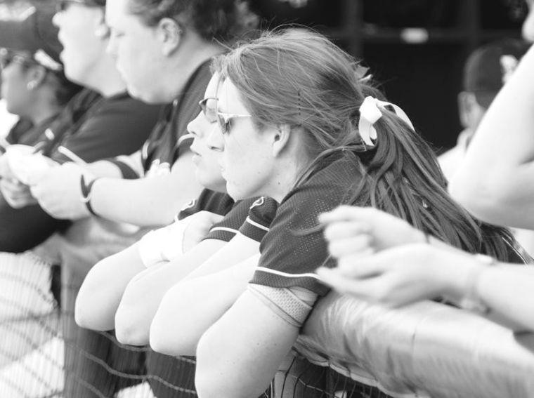Several+softball+players+look+on+solemnly+from+the+home+dugout+as+their+team+struggles+through+a+school-record+losing+streak.