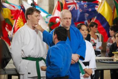 During a fiesta demonstration, karate instructor Doug Bedsaul finishes a taekwondo form upon a green belt, Ken Meehan.
