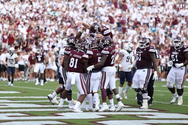The offense celebrates with Deddrick Thomas. He caught a 10-yard pass from QB Nick Fitzgerald for a touchdown before halftime.