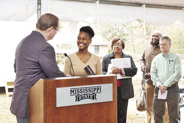 President Mark E. Keenum presents Lou'Quan Lucious with a family Bible at the Maroon Edition home dedication on Dec. 17.