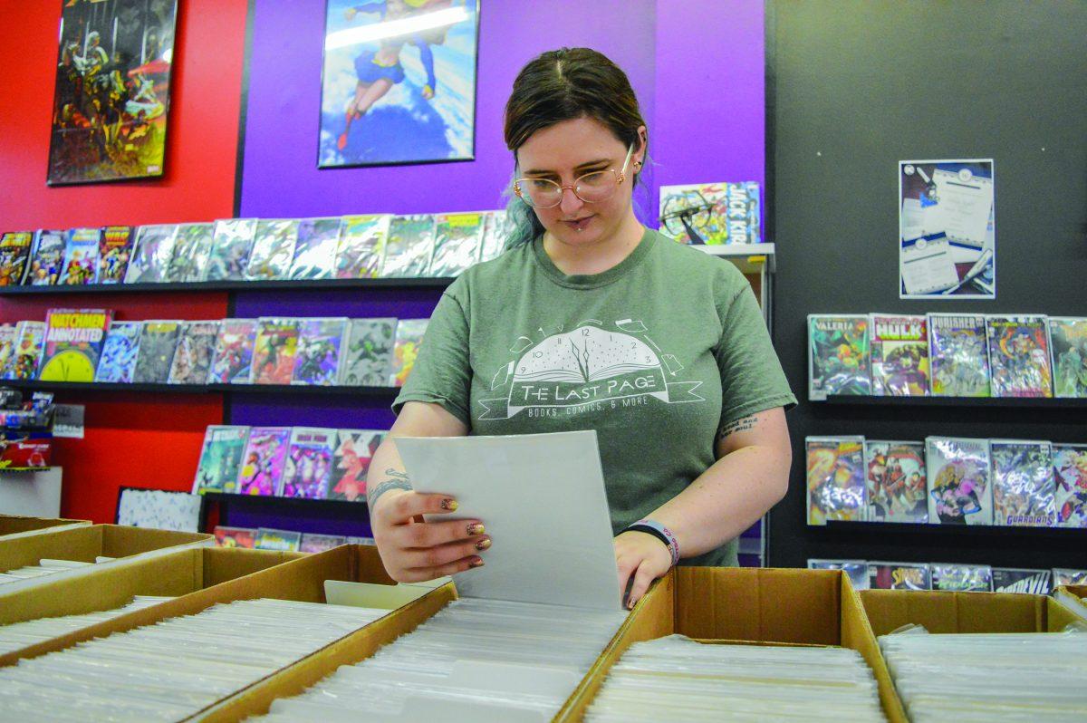 Skyland Thompson, owner of The Last Page, looks through the store’s comic book selection.
