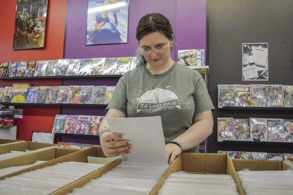 Skyland Thompson, owner of The Last Page, looks through the store’s comic book selection.