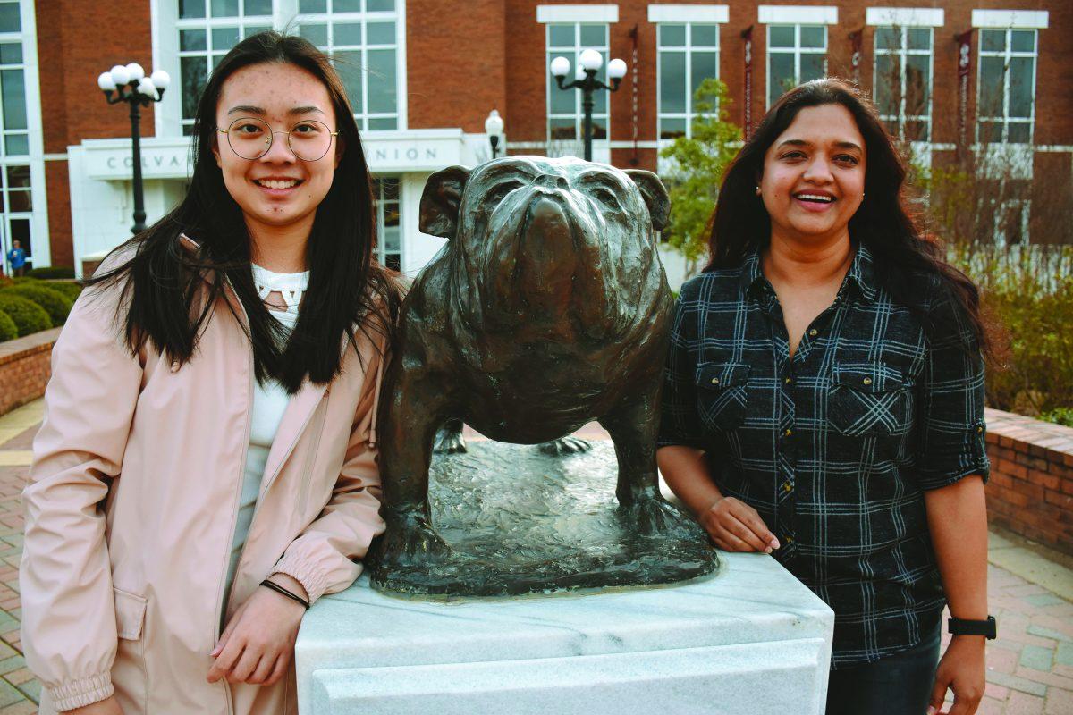 Yongxin Yu, junior landscape architecture major, and Malavika Jinka, applied anthropology graduate student, pose by the Bully statue outside the Union.