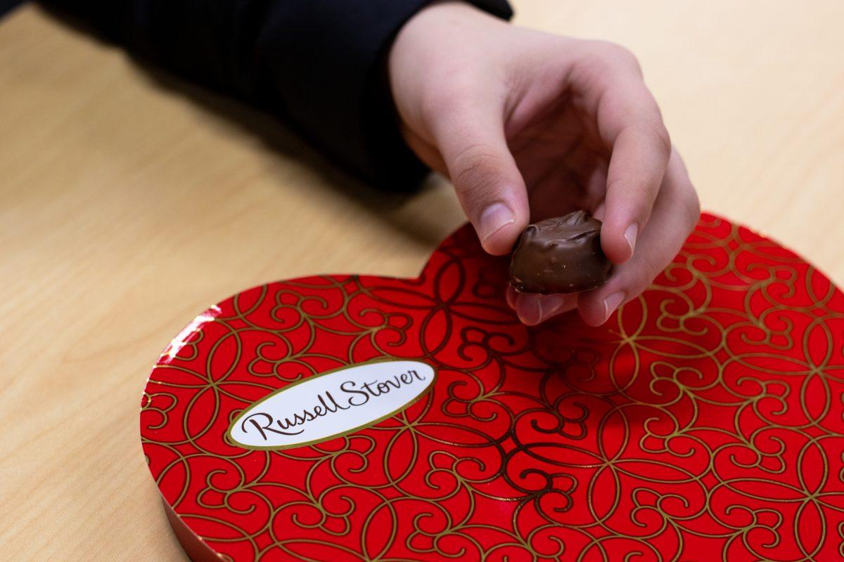 Joshua Stewart picks out his favorite chocolate with a strawberry creme filling from a Russell Stover box.