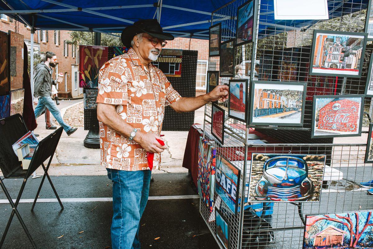 A local artisan sold his paintings and artwork at one of the many booths located at this year’s Cotton District Arts Festival.
