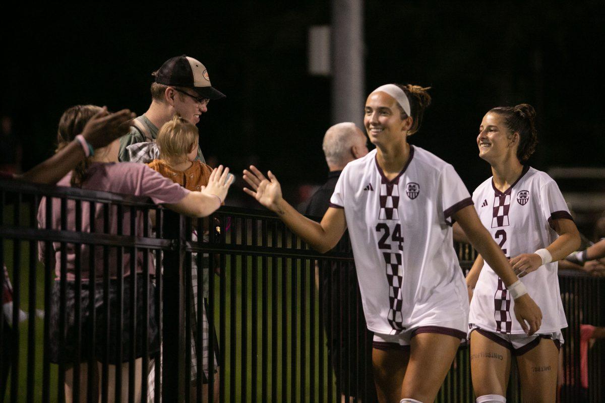 Fans celebrating a win with graduate forward Kennedy White and sophomore defender Molly McDougal.