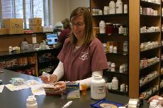 Jennifer Cougle, pharmacist at the Longest Student Health Center, prepares prescriptions for pseudoephedrine and Mucinex at the pharmacy Monday. Students are required to wear face masks in the center due to the high volume of flu cases being treated.