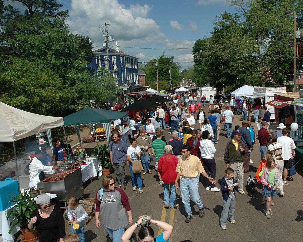 People peruse local arts and craft booths at the 2015 Cotton District Arts Festival in Starkville, Mississippi. 