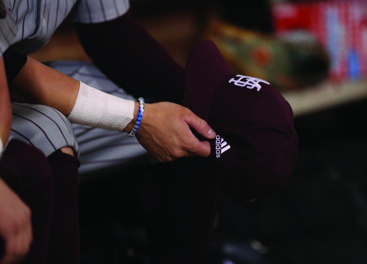 An Mississippi State University baseball player hold his hat in the dugout during MSU’s 12-1 win over Jackson State University on Wednesday night.