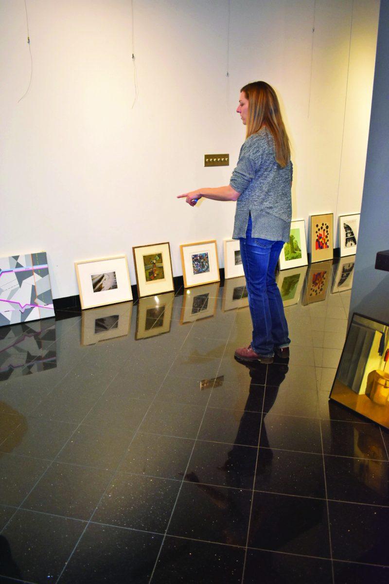 Lori Neuenfeldt, a graduate from Florida State University, plans the layout for the new “Collect 50” gallery. 
