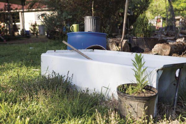 Common household objects, such as coffee mugs, bathtubs, and even trashcans, are placed sporadically through Nappe's garden to hold gardening materials, soil, and plants. 