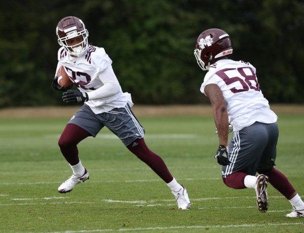 Brian Cole, junior safety, works on ball handling in a drill with Tyler Dunning, freshman linebacker, on Tuesday at spring practice.