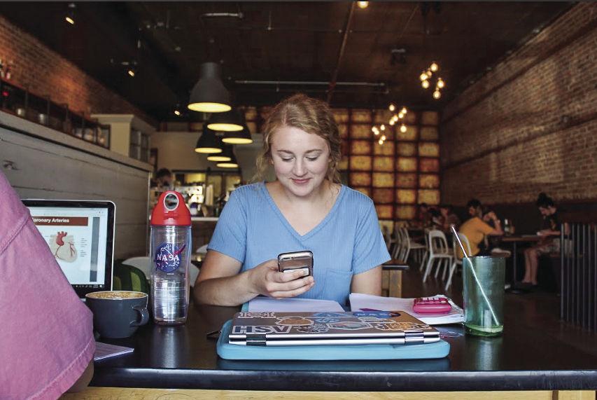 Becky Stewart, senior industrial engineering major, uses the apps on her phone to connect with the university while studying off campus with classmates.