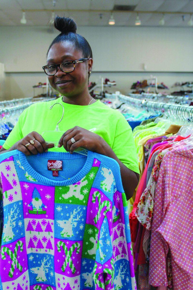 Lasondra Page, assistant manager of Starkville’s Palmer Home Thrift Store, holds up one of her favorite finds from the store’s sweater collection.