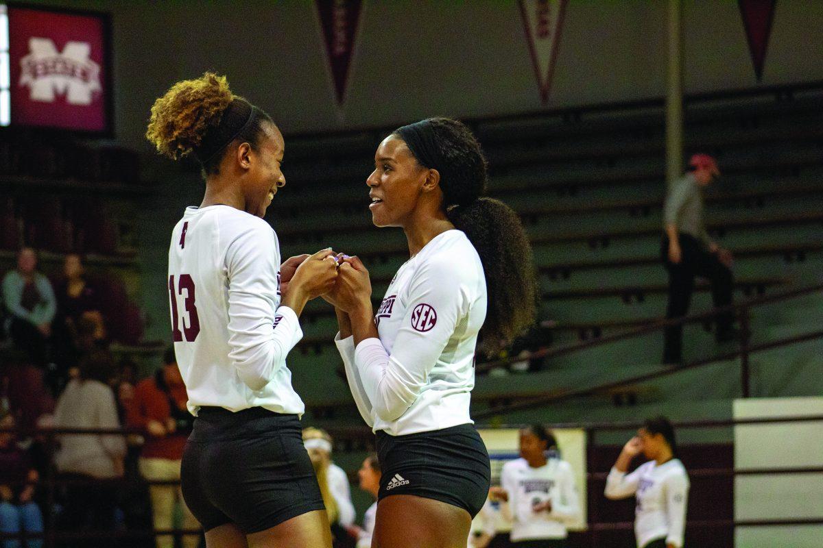 Gabby Wadden and Deja Robinson fist bump each other in a game. Both are sophomores.