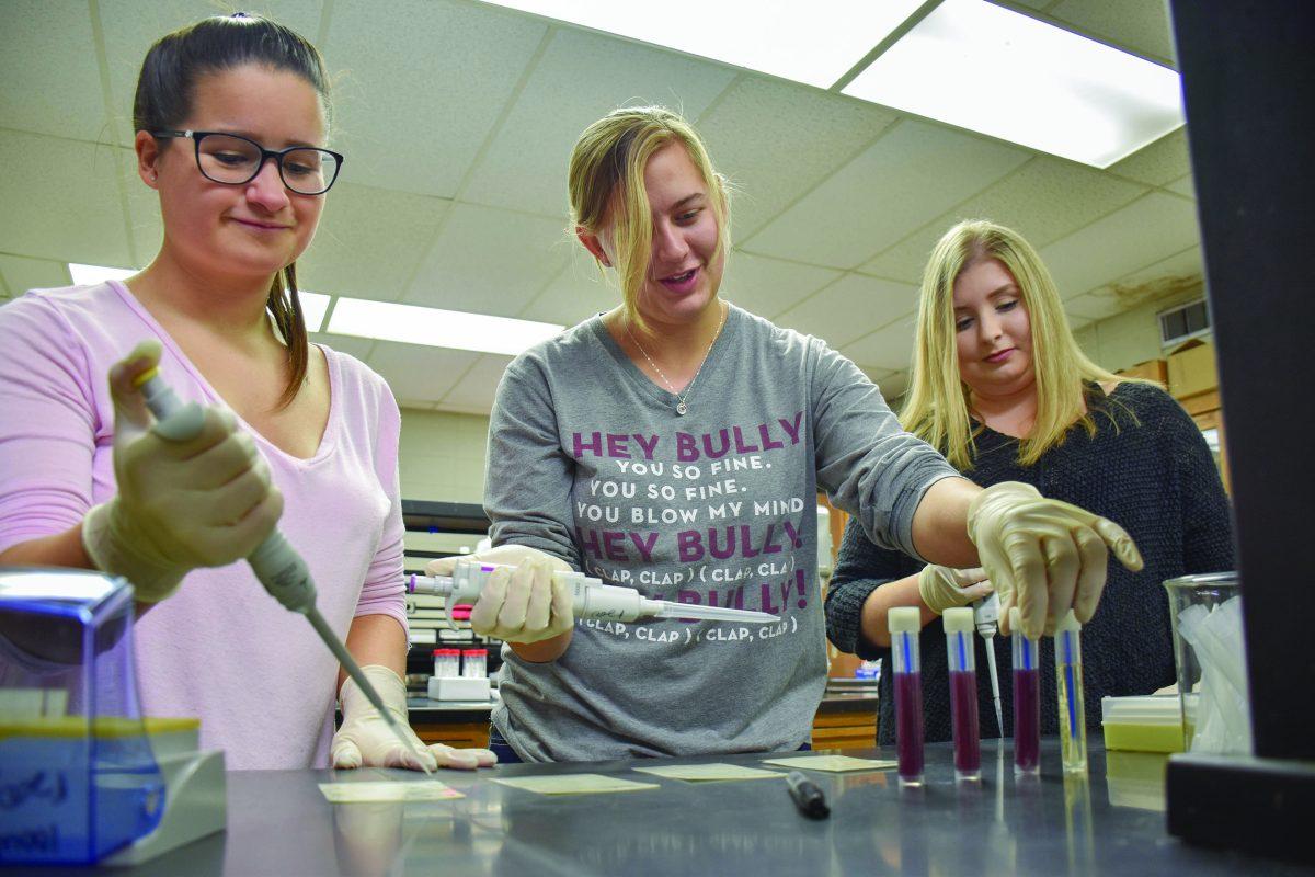 Taylor Ladner, Kyla Asher and Brooke Bain, members of the new Pipetting Club, practice laboratory techniques in the Herzer Food Science Building.