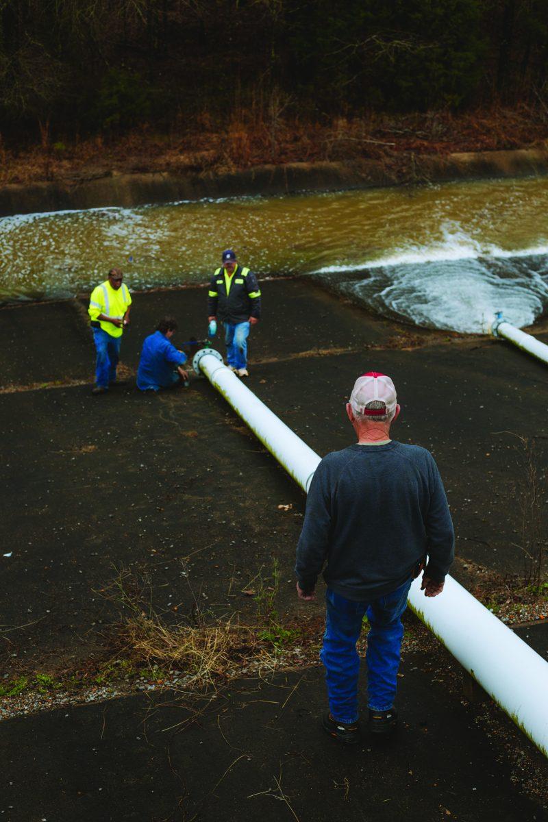 County officials attempt to repair a drainage pipe at the back of the Oktibbeha County Dam.