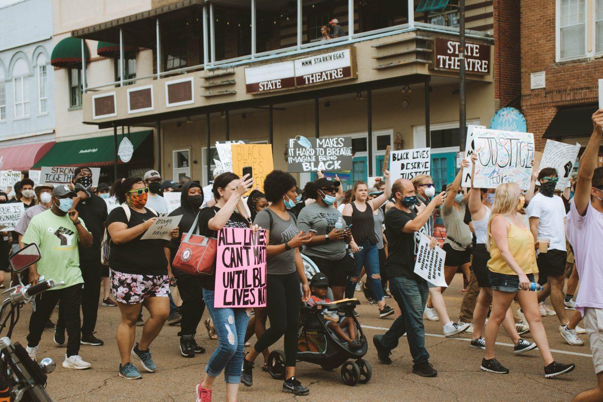 Protestors march through downtown Starkville towards the MSU campus.