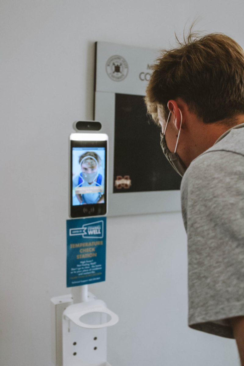 Sam Bradford, a freshman majoring in mechanical engineering, checks his temperature in the Colvard Student Union with the Cowbell Well temperature kiosk.