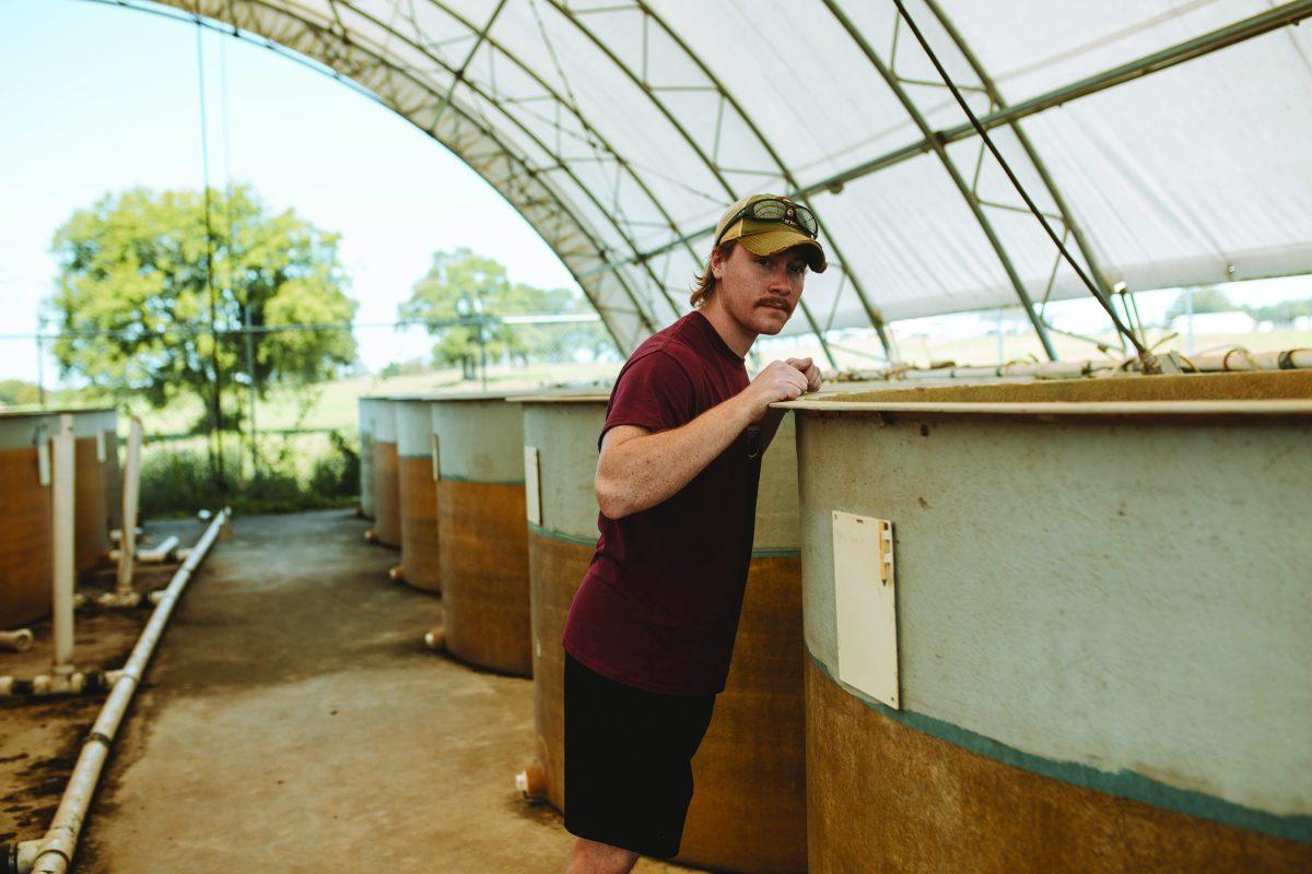 MSU graduate student Josh Neary overlooks tanks at South Farm aquaculture facility.