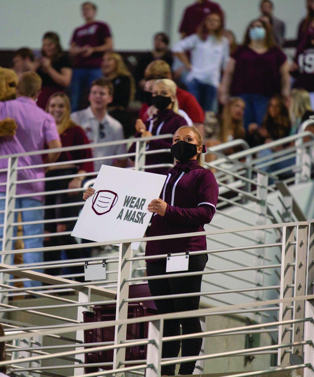 An MSU cheerleader reminds the crowd to wear their mask in efforts to keep Bulldog fans safe.