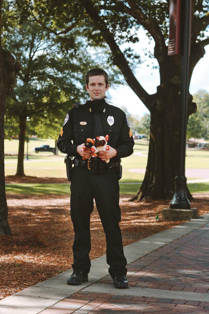 Campus police officer Wesley Bunch poses with the stuffed animals he gives to children.