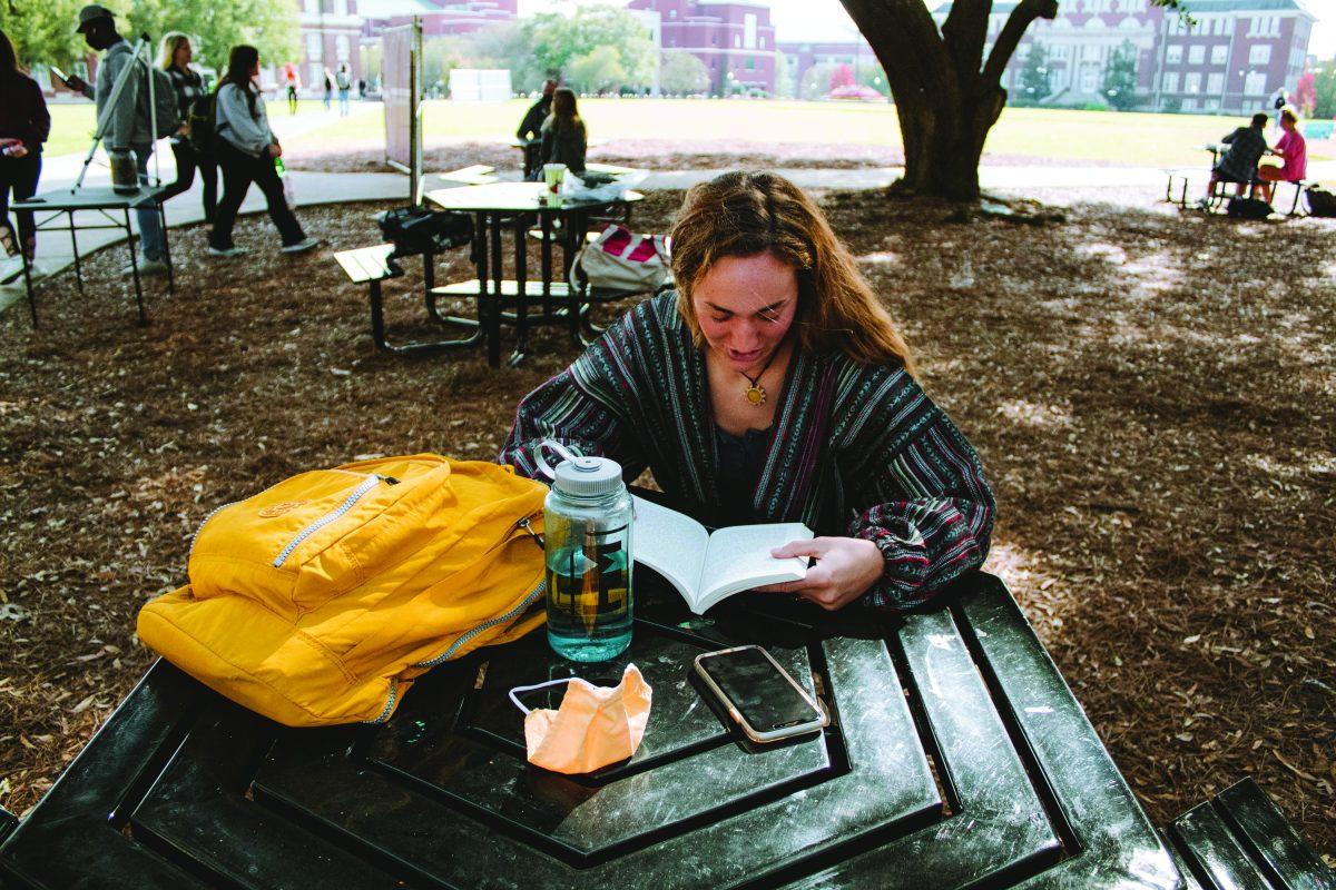 MSU senior Hannah Covington cracks open a book on the Drill Field, just one of the many creative study spots students have turned to.
