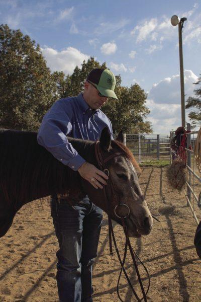 MSU professor and horse specialist Clay Cavinder poses with a horse at the Equine Unit.