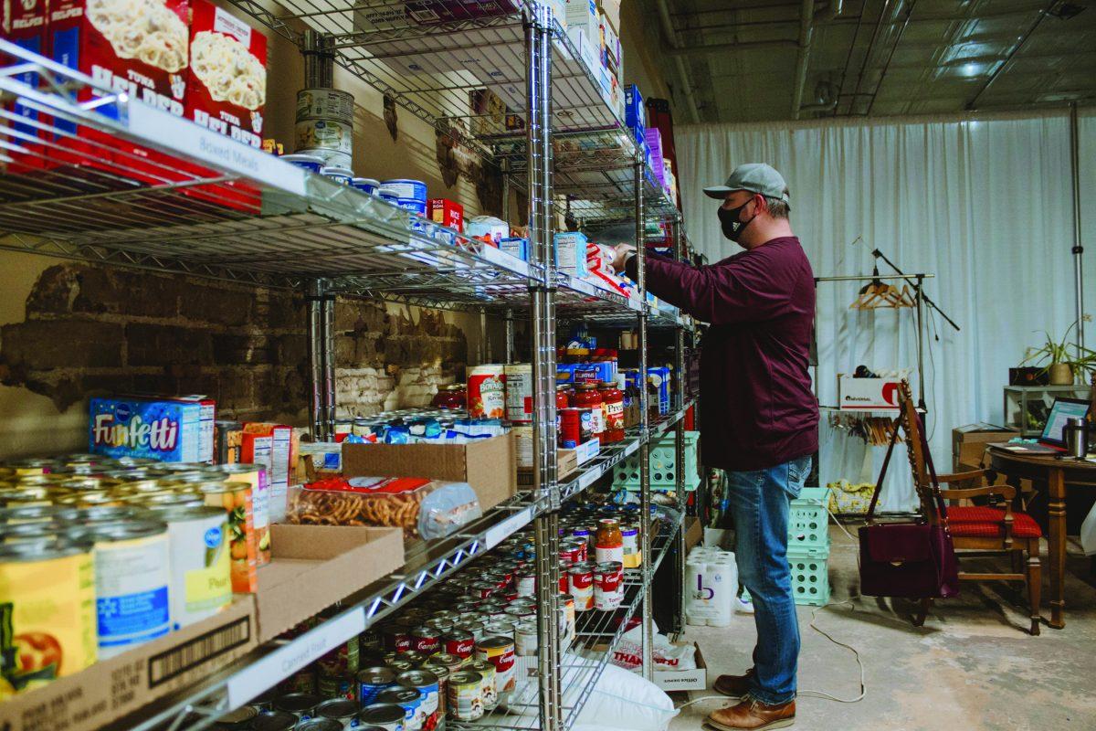 Josh Herrington, co-owner of Dunkington, stocks the public pantry as part of the Starkville Strong initiative.