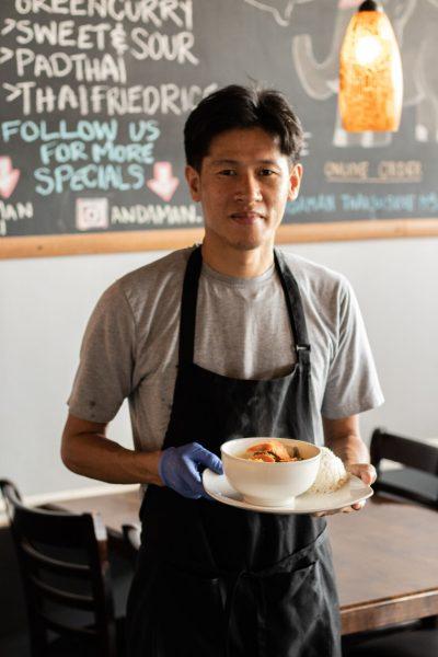 The owner of Andaman Thai, Vien Vong, is pictured with traditional yellow curry.