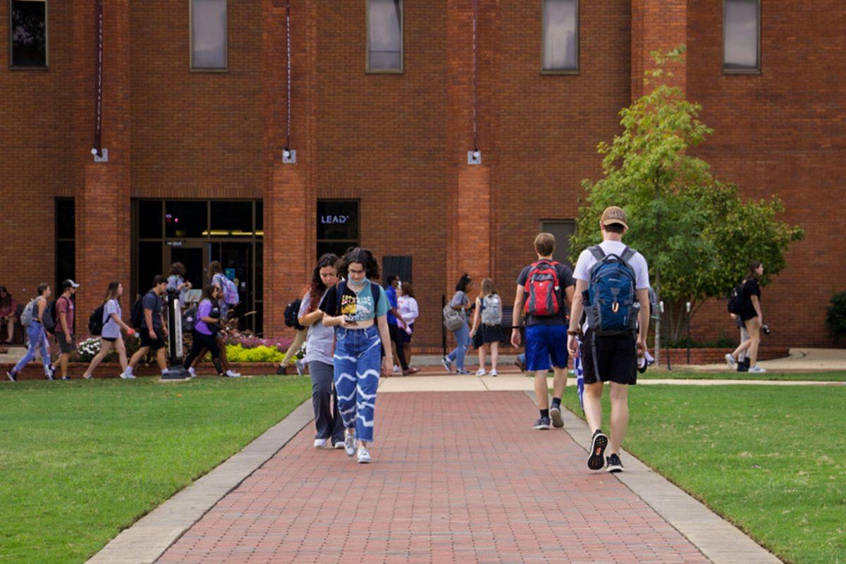 Students walk on pathways in front of McCool Hall. The paths on the Drill Field are plentiful but not practical when walking to class.