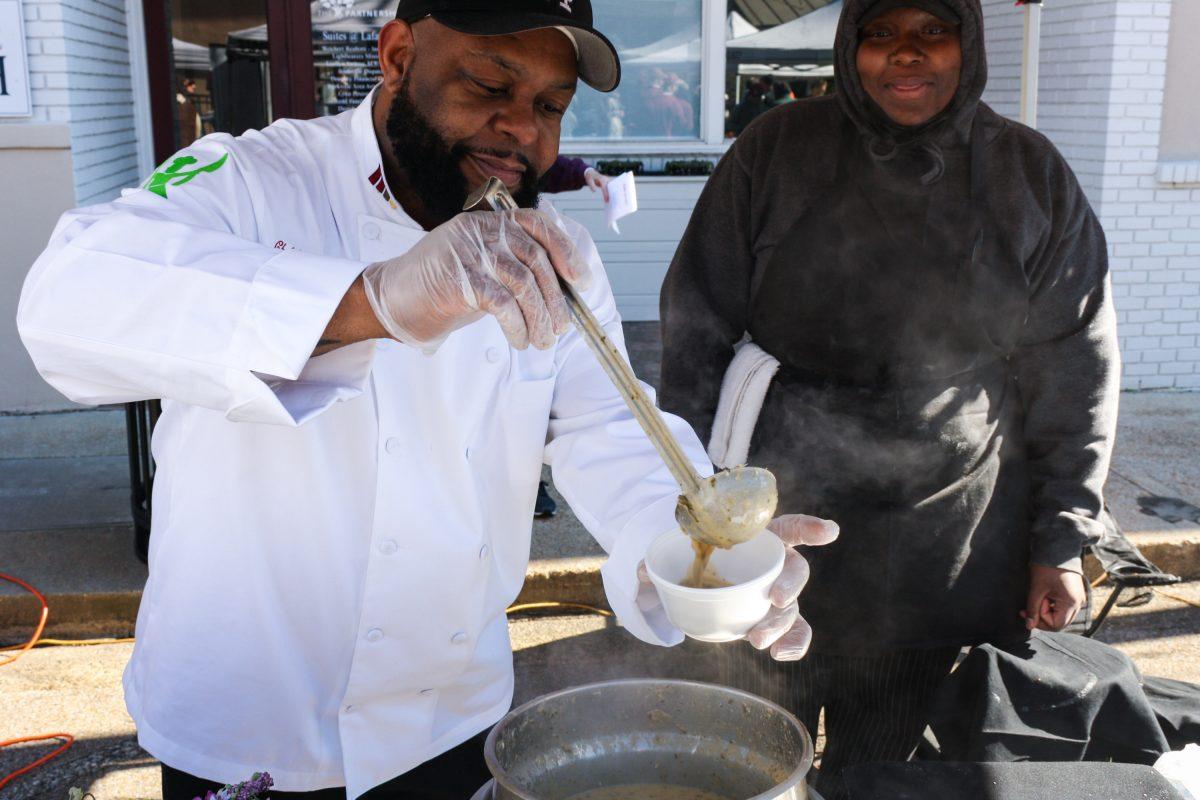 Chef Leon Jefferson serves a cup of his roasted kale and artichoke soup with smoked gouda and pork belly. Jefferson took home first place at the event.