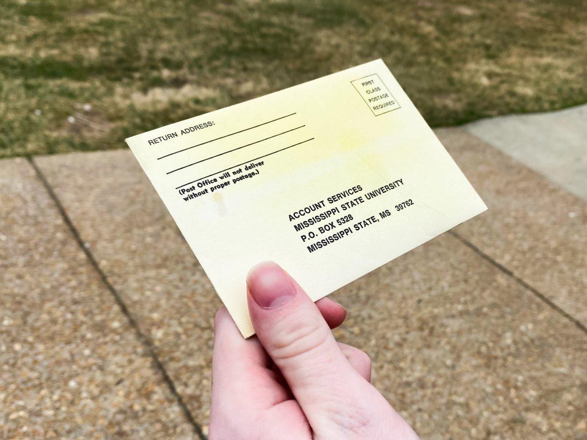 A student holds the infamous yellow envelope that parking service uses to give tickets