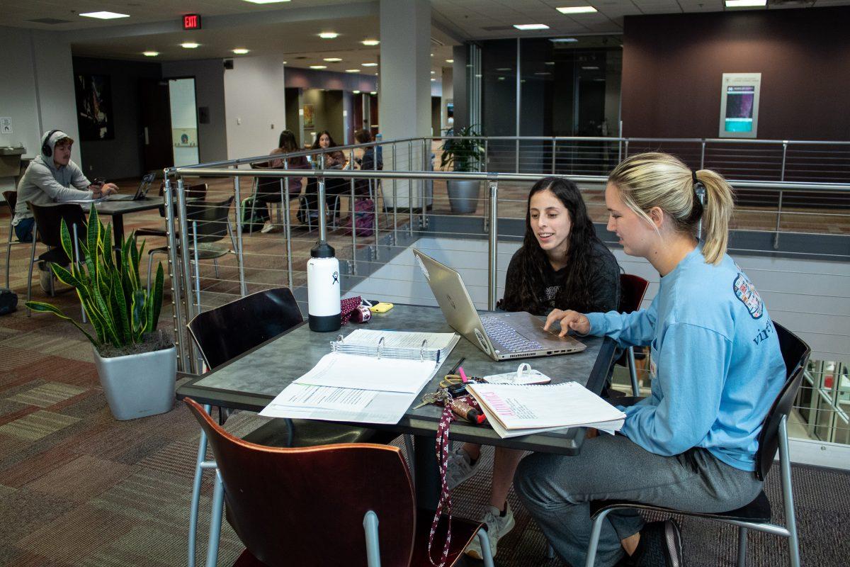 Two students are studying in the Colvard Student Union.