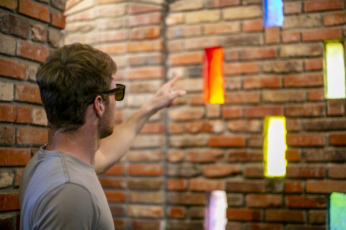Student Trayton Taft uses colorblind glasses to help him identify the colors of the windows in the Chapel of Memories.