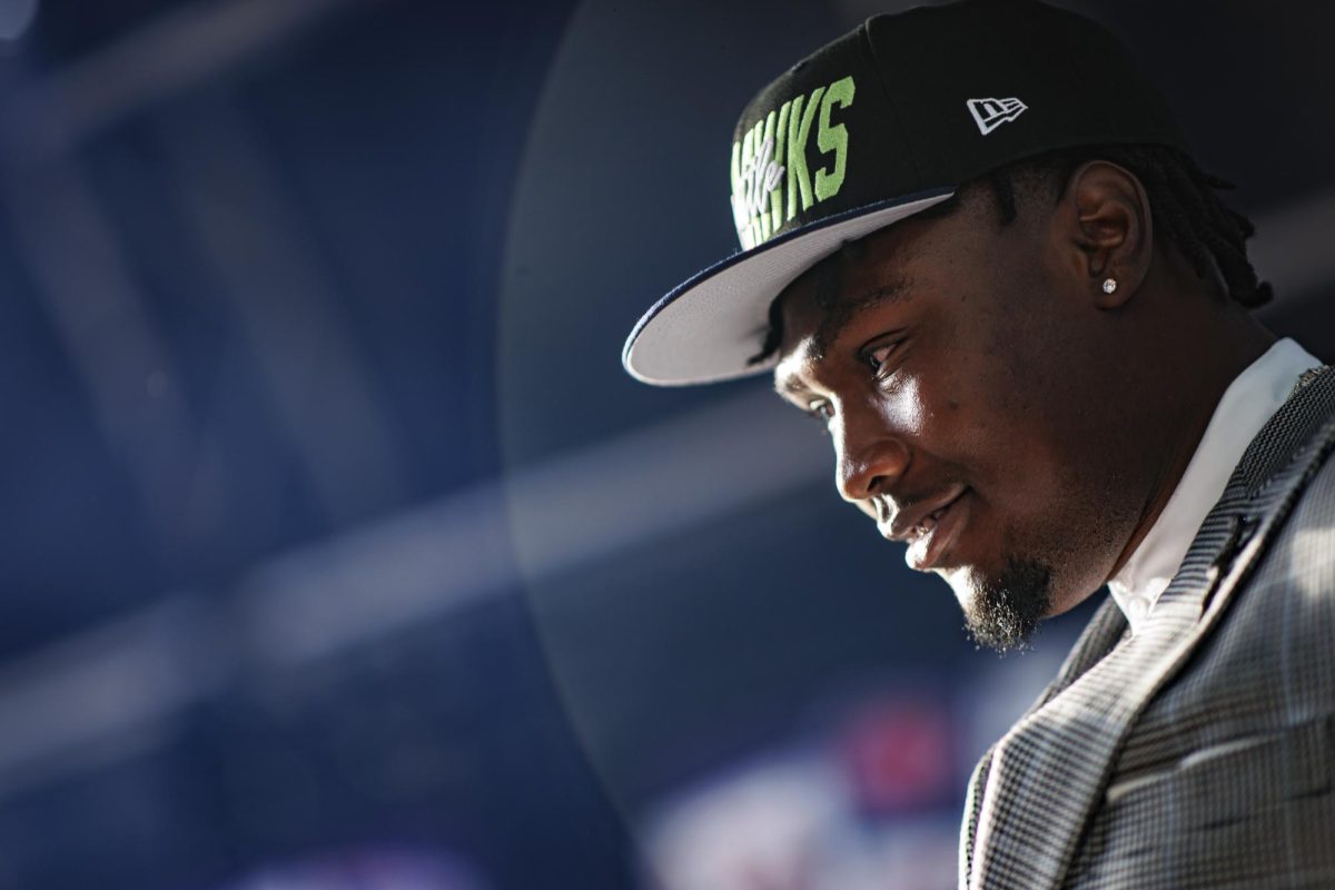 Former Mississippi State wide receiver Charles Cross smiles in a Seattle Seahawks hat after being drafted at the 2022 NFL Draft. [Austin Perryman/MSU Athletics]