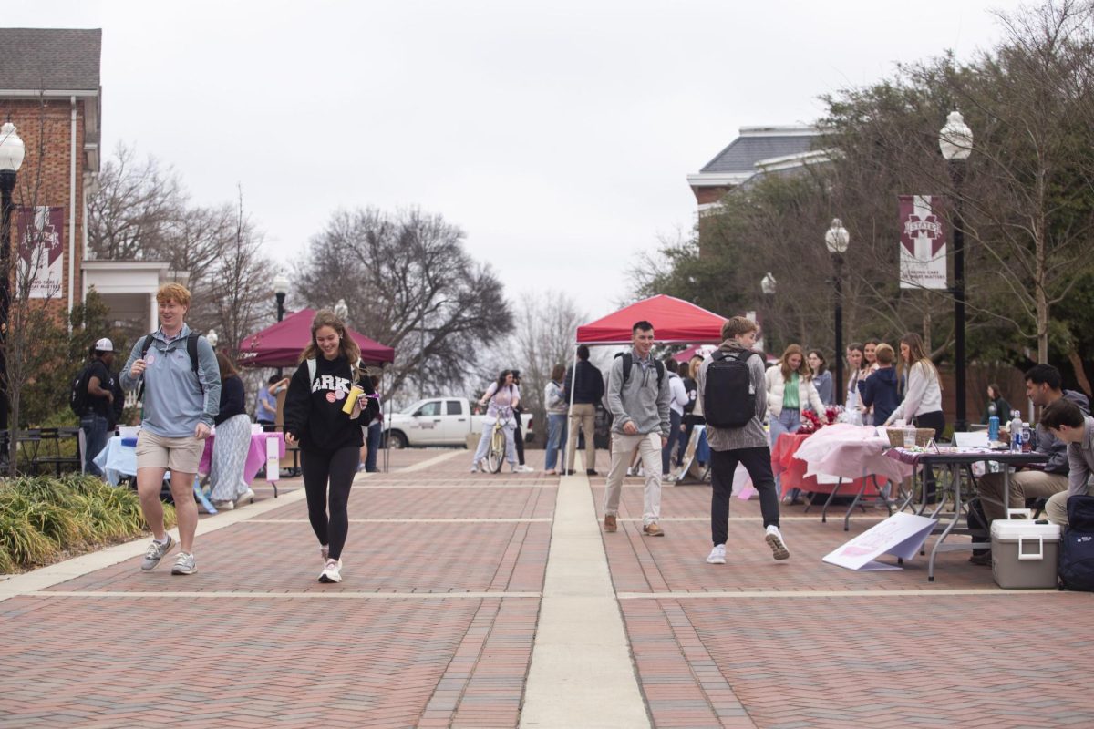 Students walk through the YMCA Plaza as candidates for Student Association seats table. 