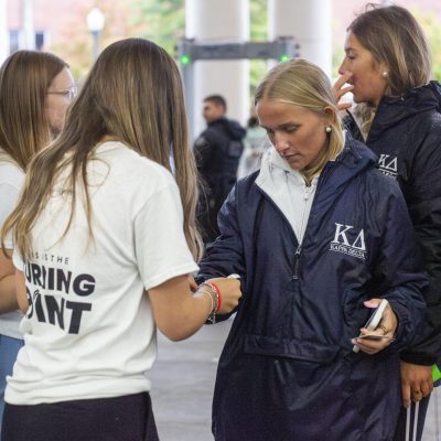 5:04 p.m. - Volunteers guide students into the pavilion. Many stood in line for hours as rain and low temperatures plagued Oxford.
