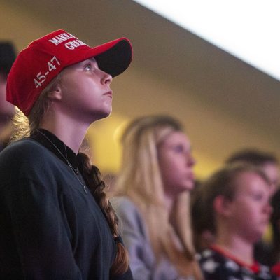 6:40 p.m. - An attendee watches as TPUSA CEO Erika Kirk speaks.