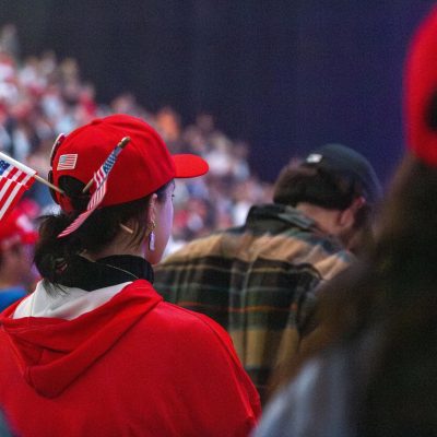 6:56 p.m. - An attendee sports two American flags and cross earrings during the event.