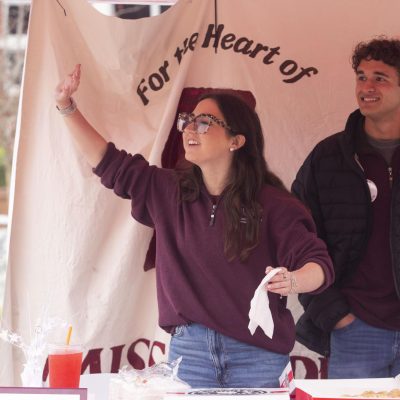 Student Association secretary and vice presidential candidate Abigail Spreen waves as she campaigns with running-mate and presidential candidate Keegan Figueroa.