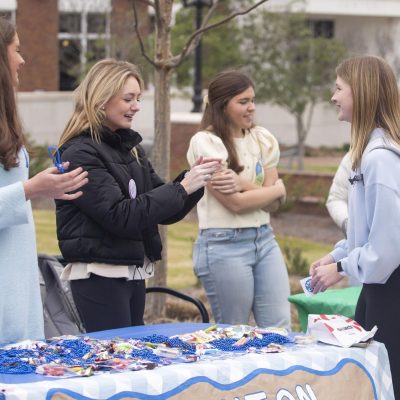 Sole secretary candidate Torie Keenum smiles while standing at treasurer candidate Cape Merrell's campaign table on Tuesday morning.