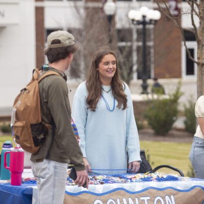 Treasurer candidate Cape Merrell smiles as she talks to students while tabling on the YMCA Plaza.