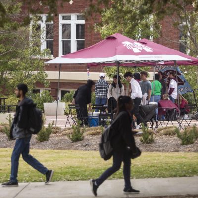 Students walk past as candidates campaign for Student Association positions.